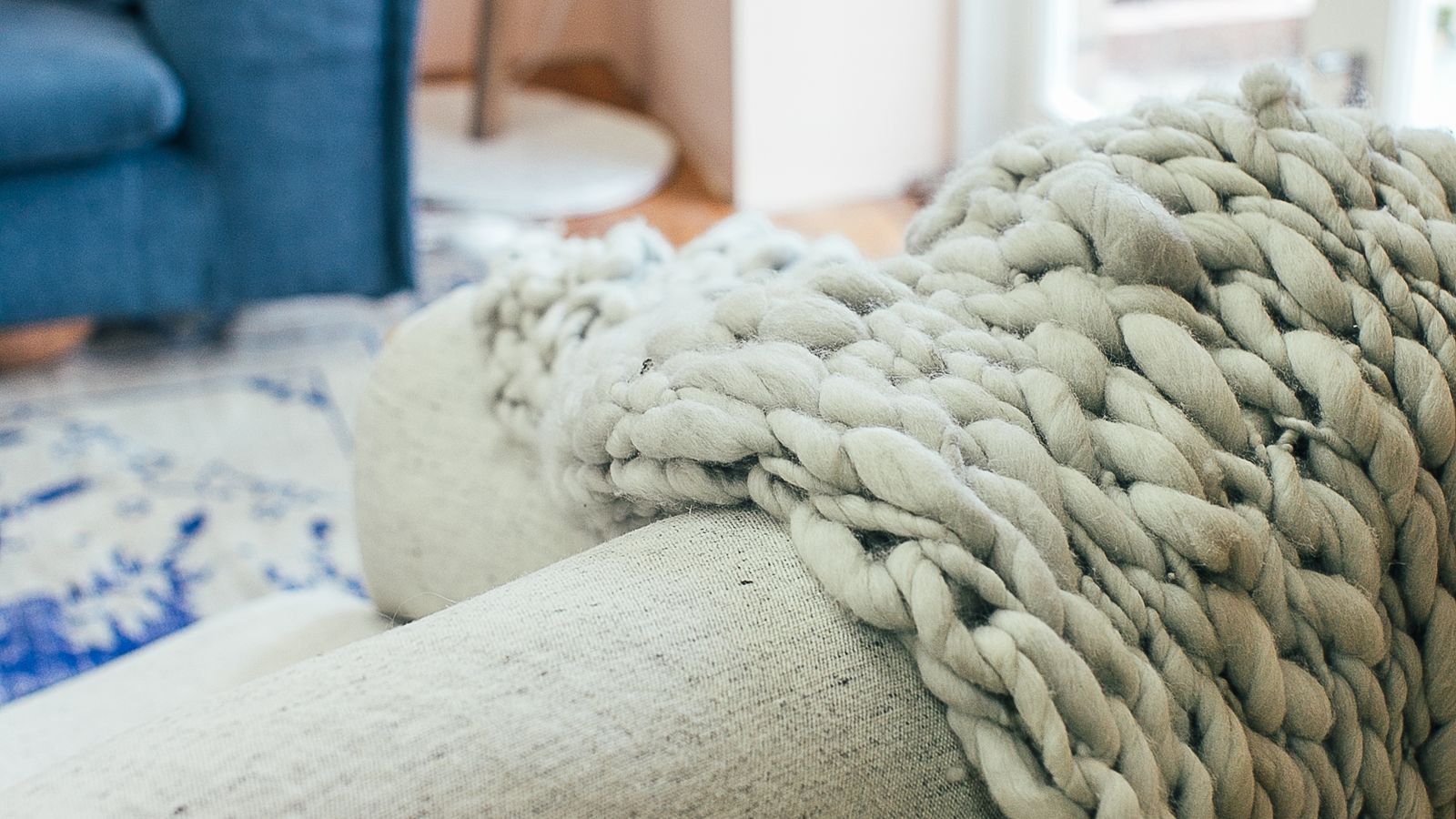Close-up of thick wool yarn stitches on a cozy knit blanket