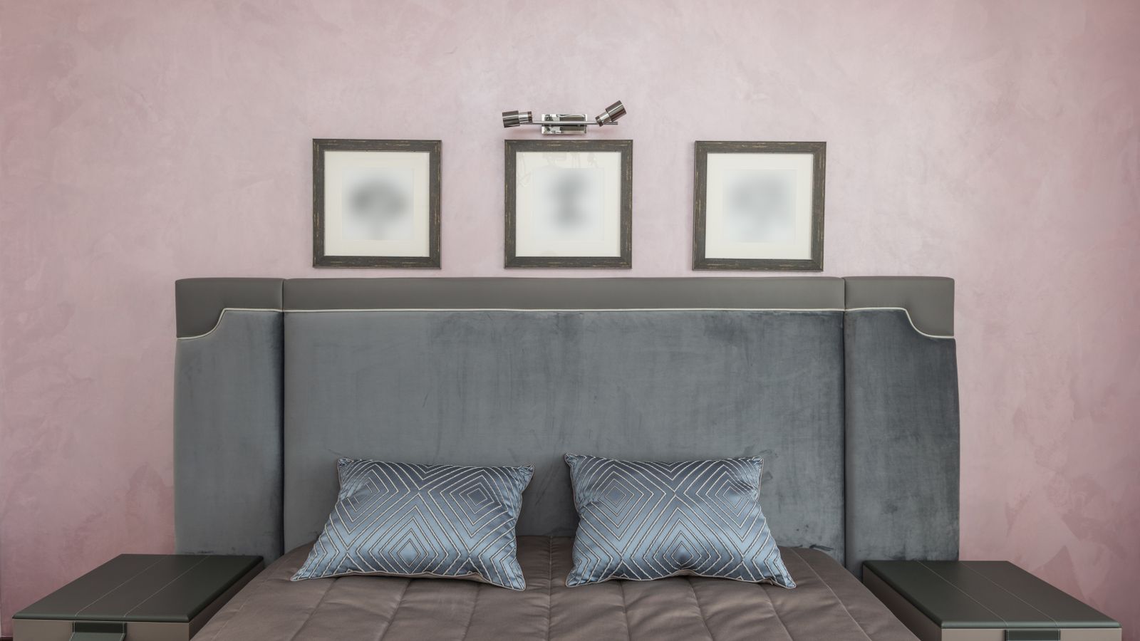 Upholstered headboard mounted against a bedroom wall behind a made bed