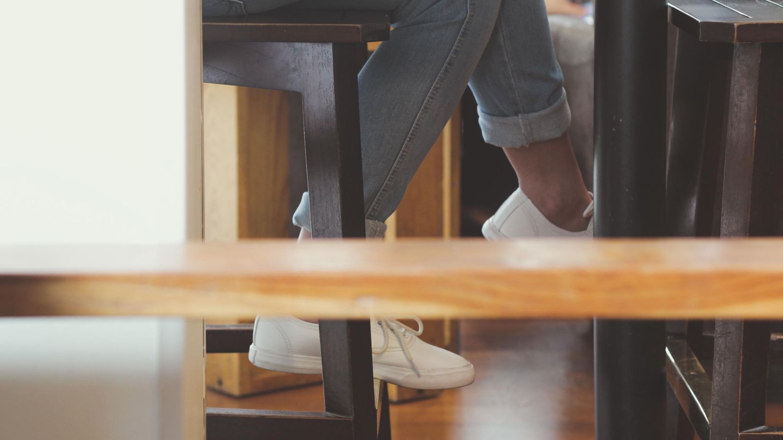 Wooden furniture legs attached to the underside of a cabinet on a hardwood floor