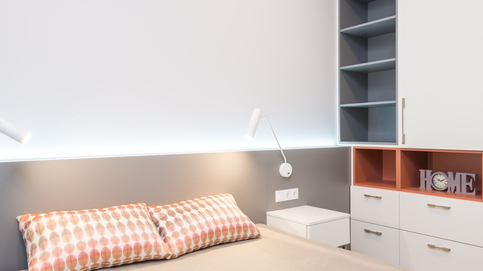 Close-up of open nightstand shelves organized with books and small storage bins