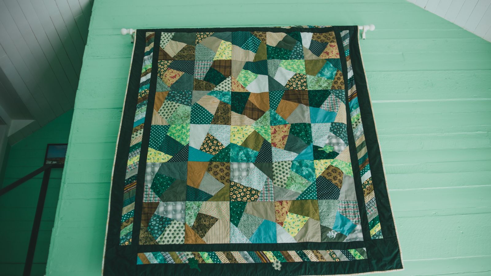 Neatly folded quilt showing stitched pattern and fabric texture on a bed