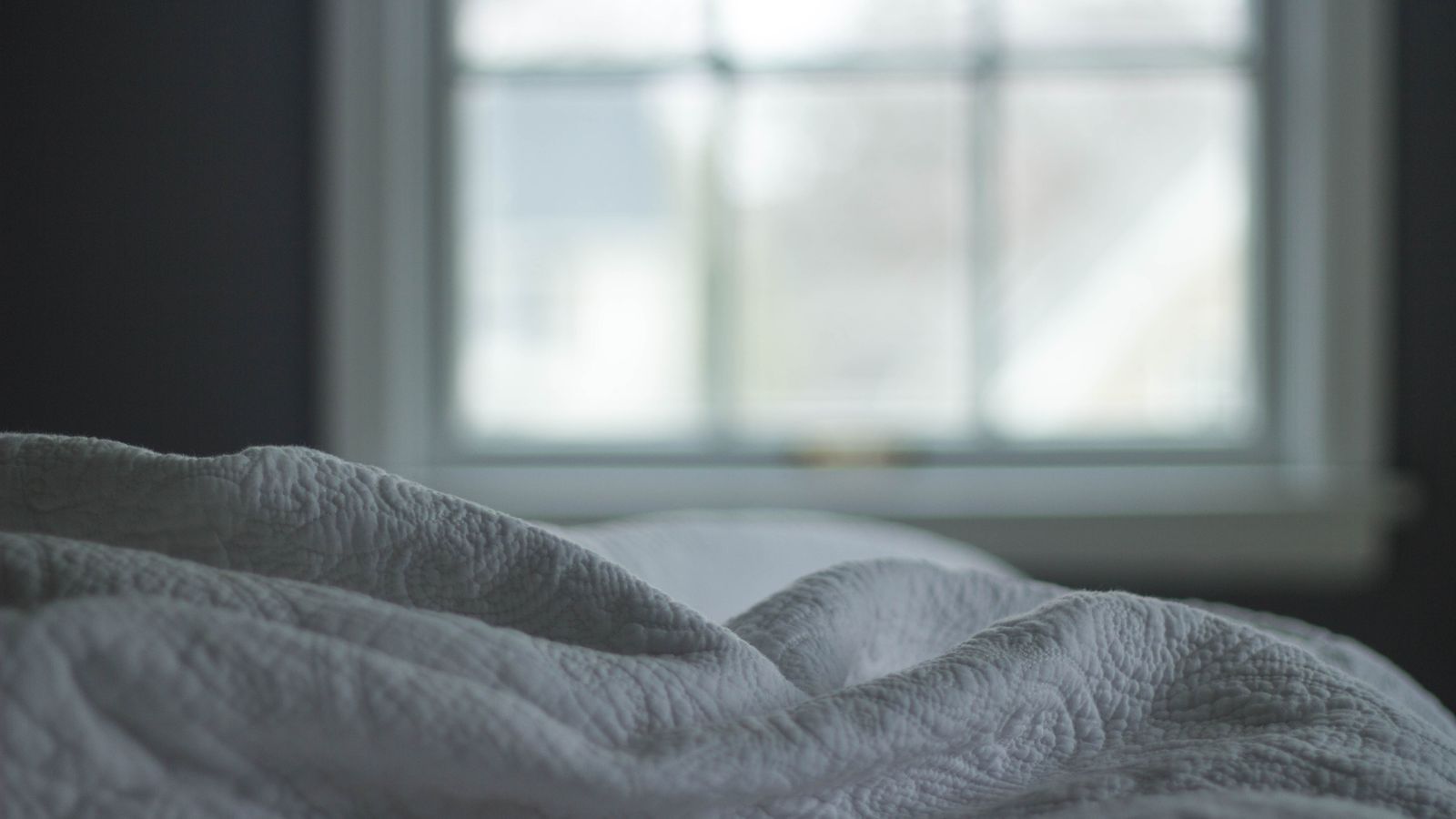 Quilt airing out and stored in a breathable fabric bag on a shelf