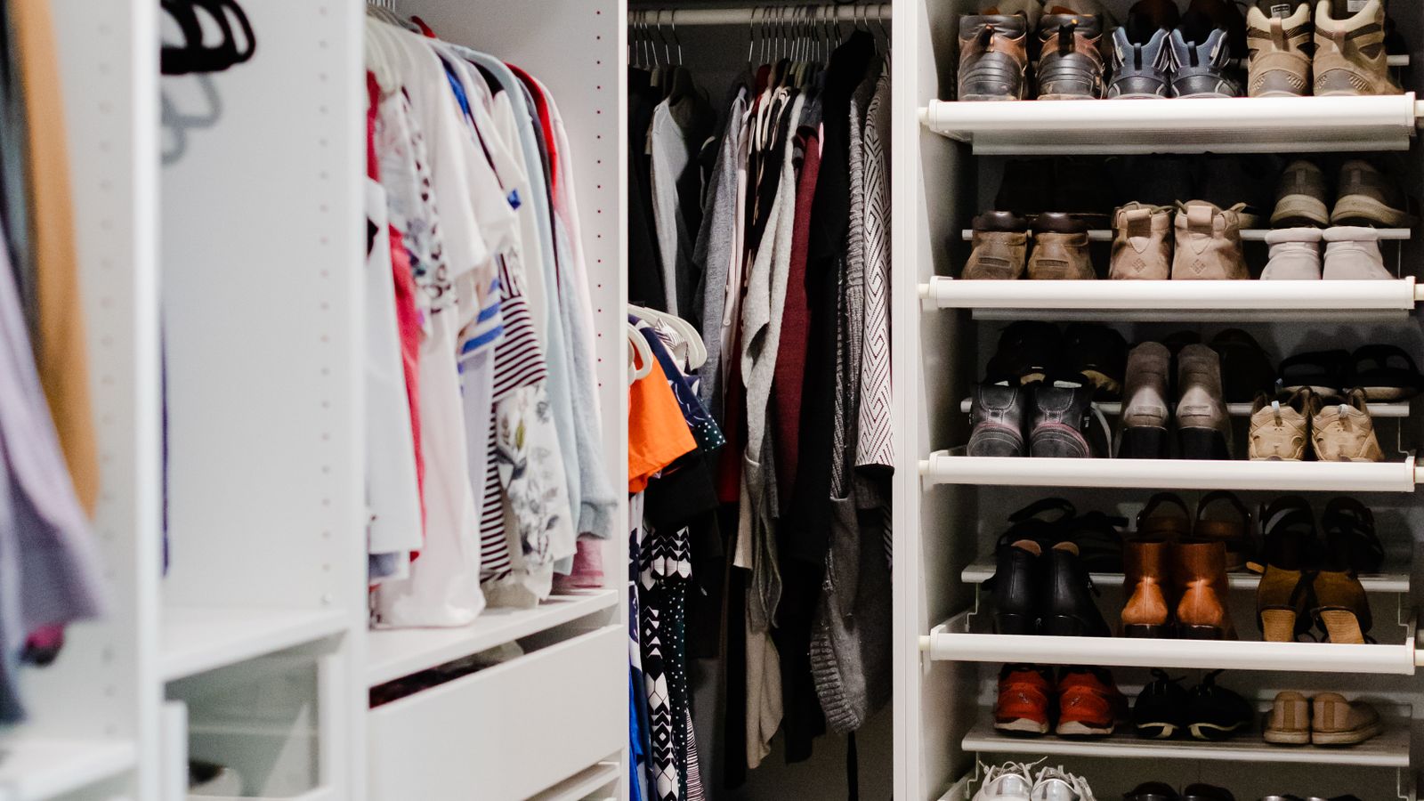 Wooden wardrobe cube shelving with neatly folded clothes and shoes