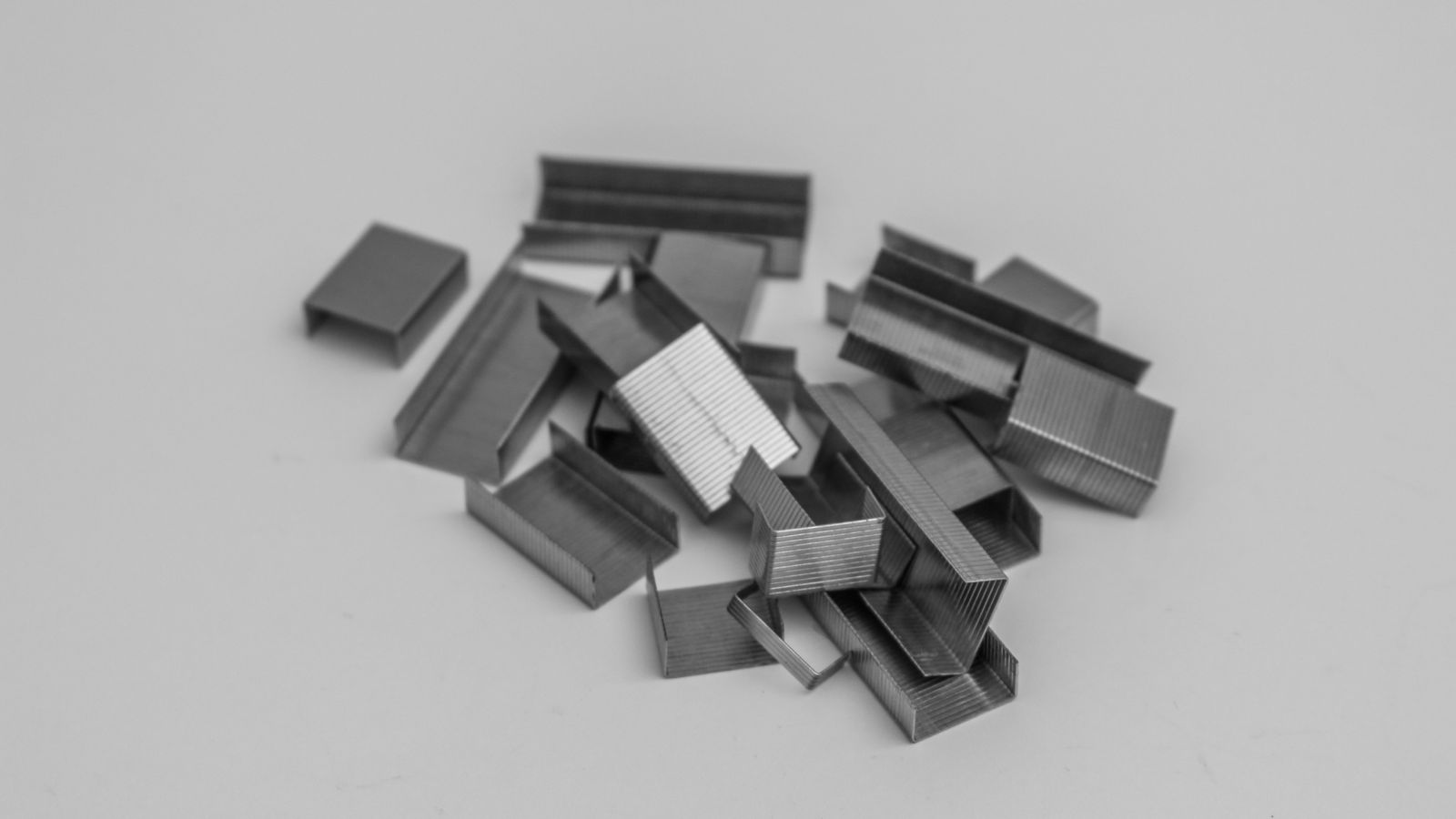 Close-up of staples and staple gun tool laid out on a workbench for furniture repair