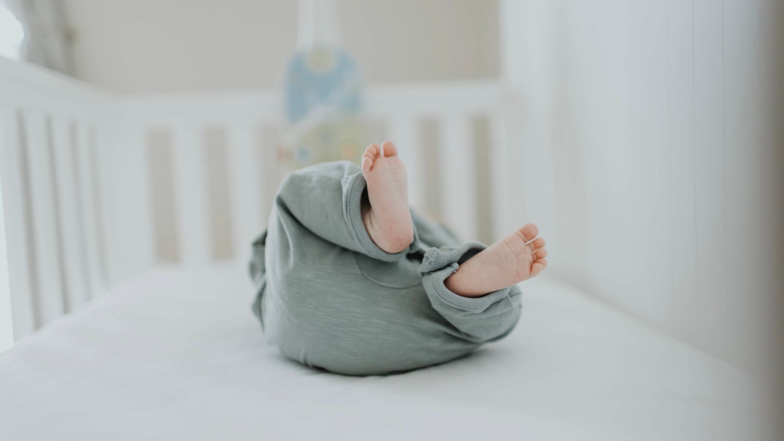 Folded crib mattress pad and baby bedding ready for washing