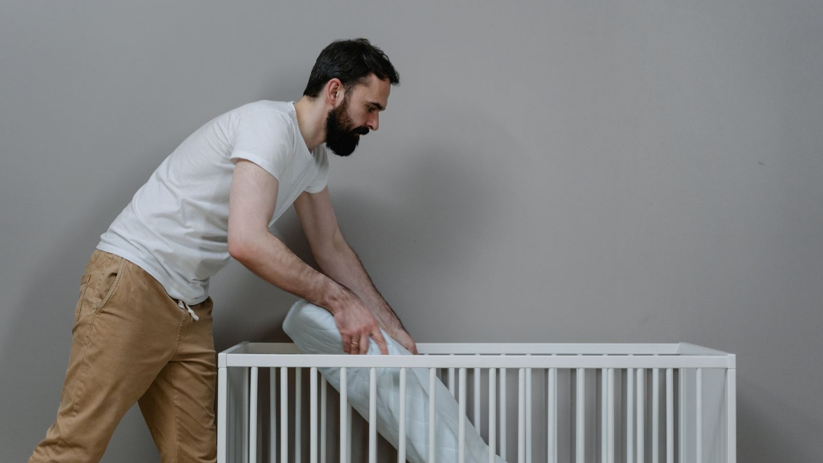 Nursery crib with clean bedding and mattress pad in place