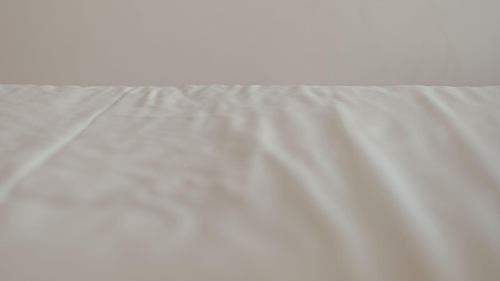 Close-up of a fitted crib sheet stretched tightly over a nursery mattress corner