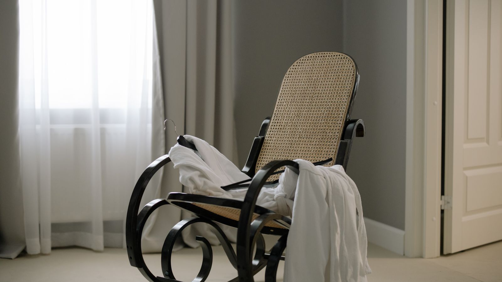 Comfortable upholstered glider chair with wood frame near a living room TV setup