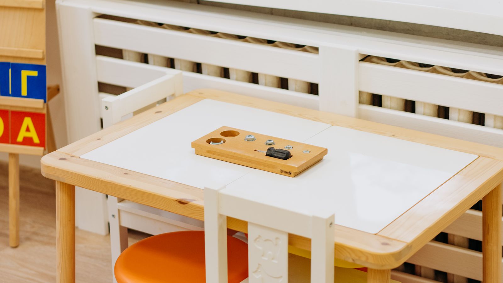 Child sitting at a small wooden kids table and chair set doing crafts