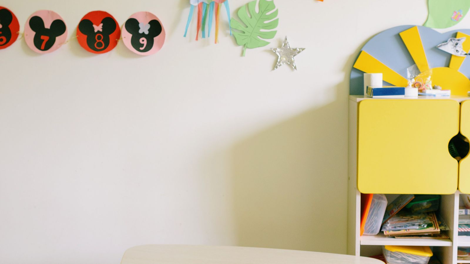 Small kids wooden table and chairs set styled in a bright playroom corner