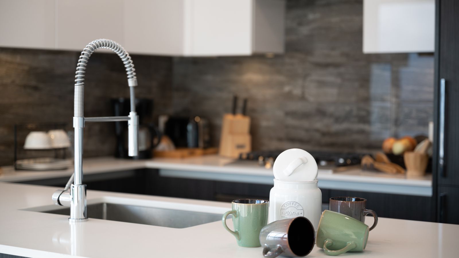 Set of clean empty glass storage canisters with wooden lids on a kitchen counter