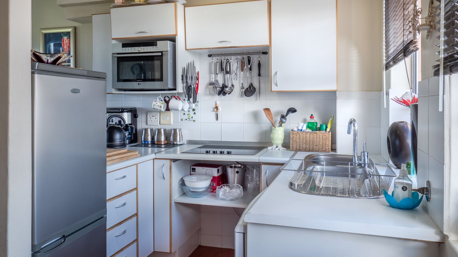 Person organizing kitchen appliances and cookware for donation or storage