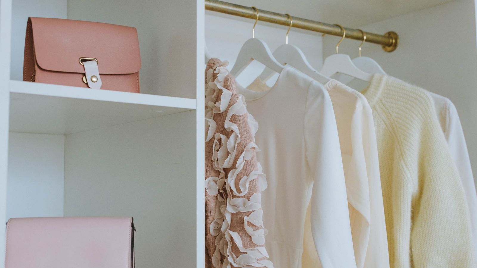 Organized closet shelving with folded clothing and storage bins