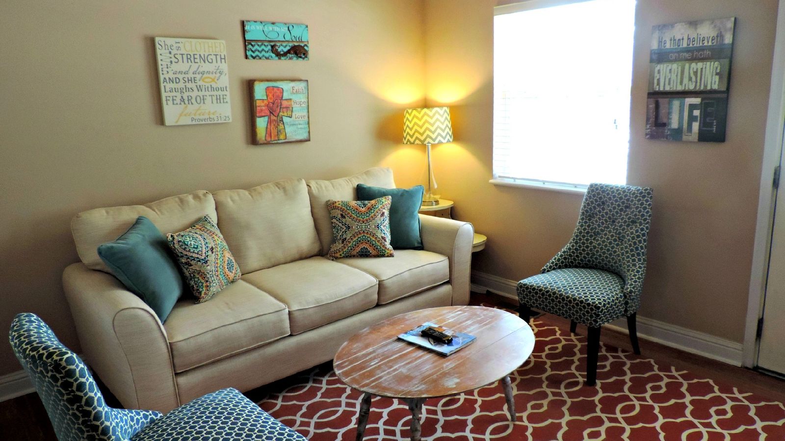 Round coffee table styled with books and a plant in a bright living room