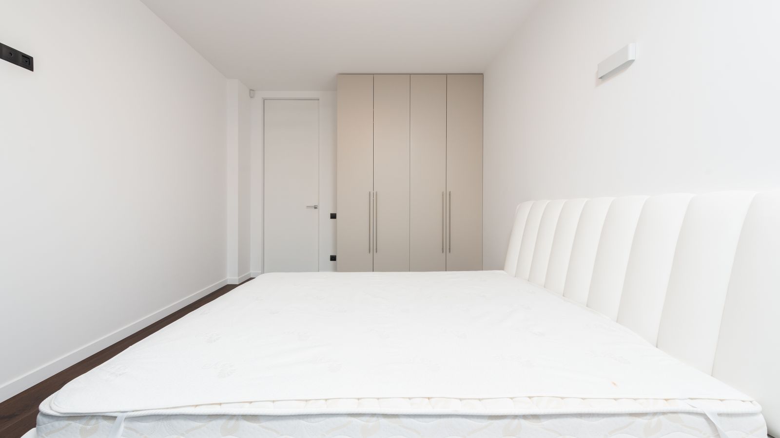 Mattress lifted off a bed frame showing the flat support board underneath