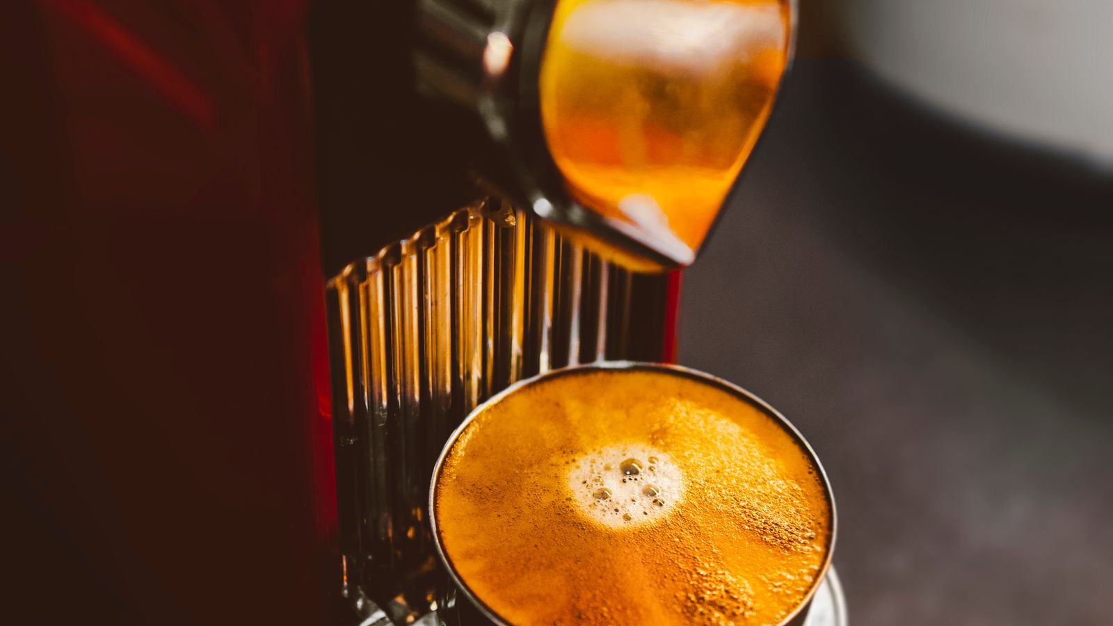 Single serve coffee maker brewing a cup of coffee on a kitchen counter