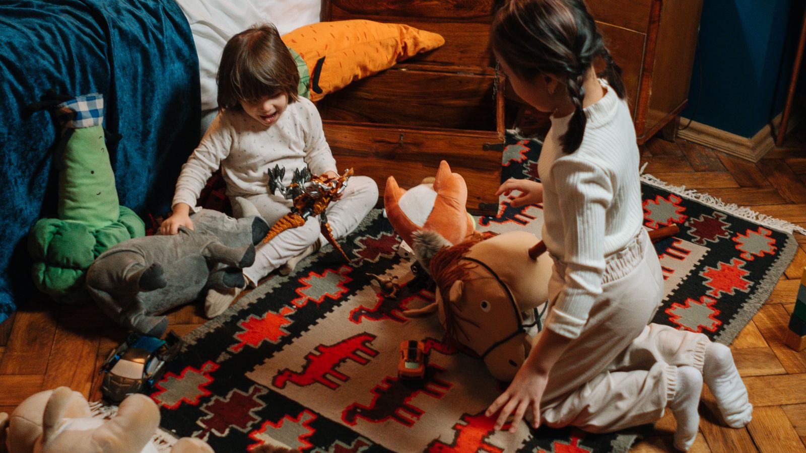 Felt and rubber rug pad being placed under a rug on a hardwood floor