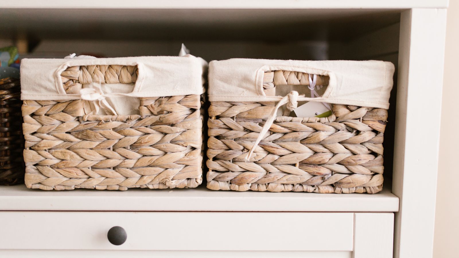Woven storage baskets neatly arranged inside a cube organizer shelf in a closet