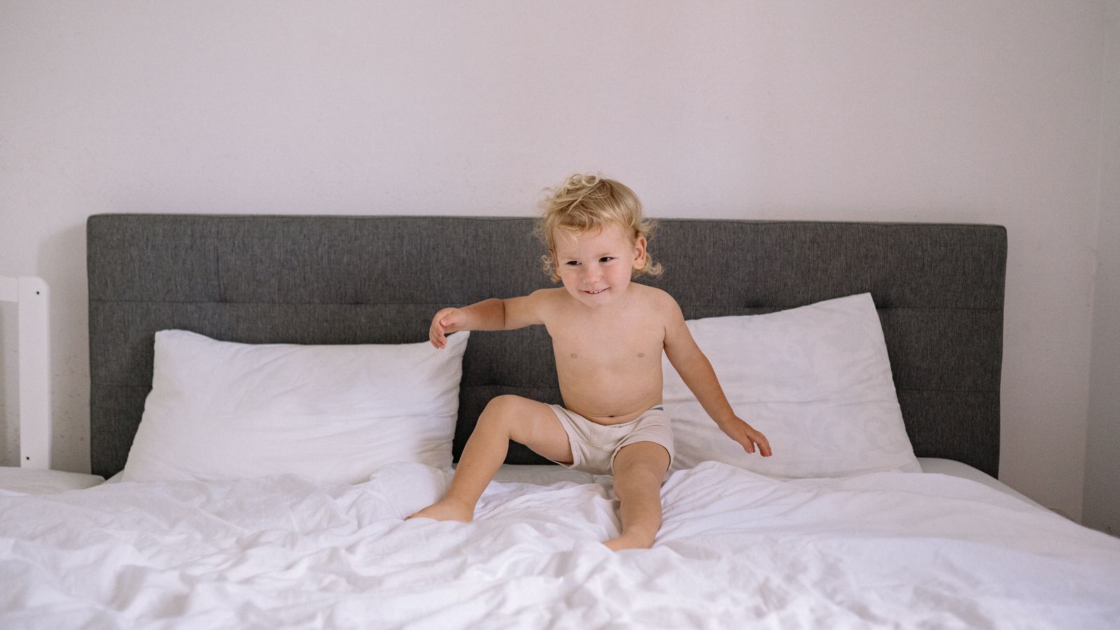 Toddler bed made up with a coordinated bedding set folded neatly beside a storage basket