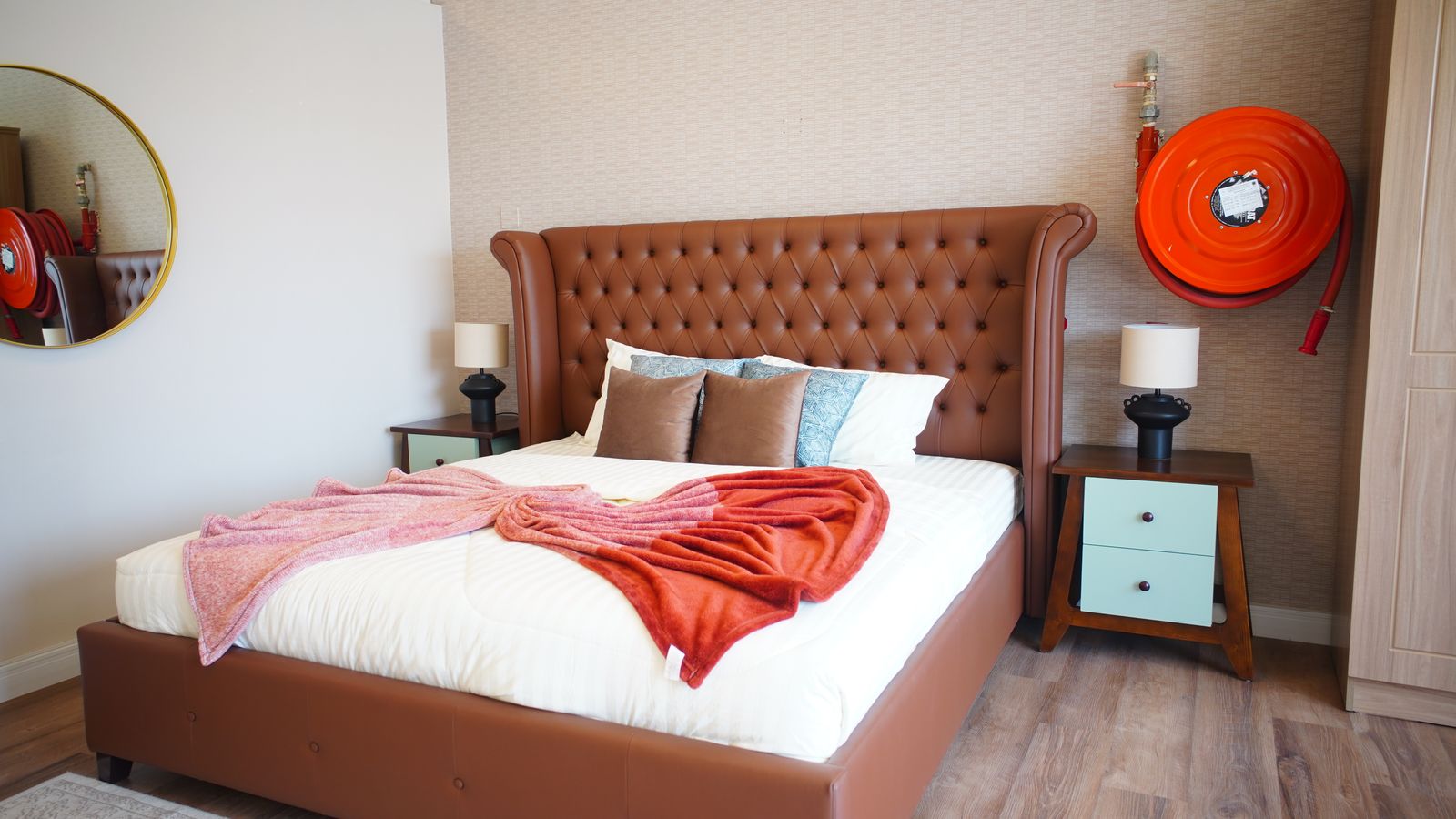 Bedroom with an upholstered tufted headboard and neatly organized bed frame setup