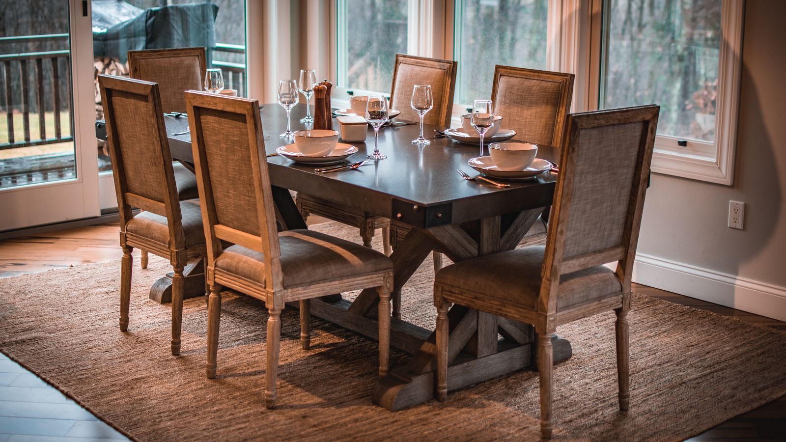 Dining room table set on a tiled floor with a jute rug anchoring the space