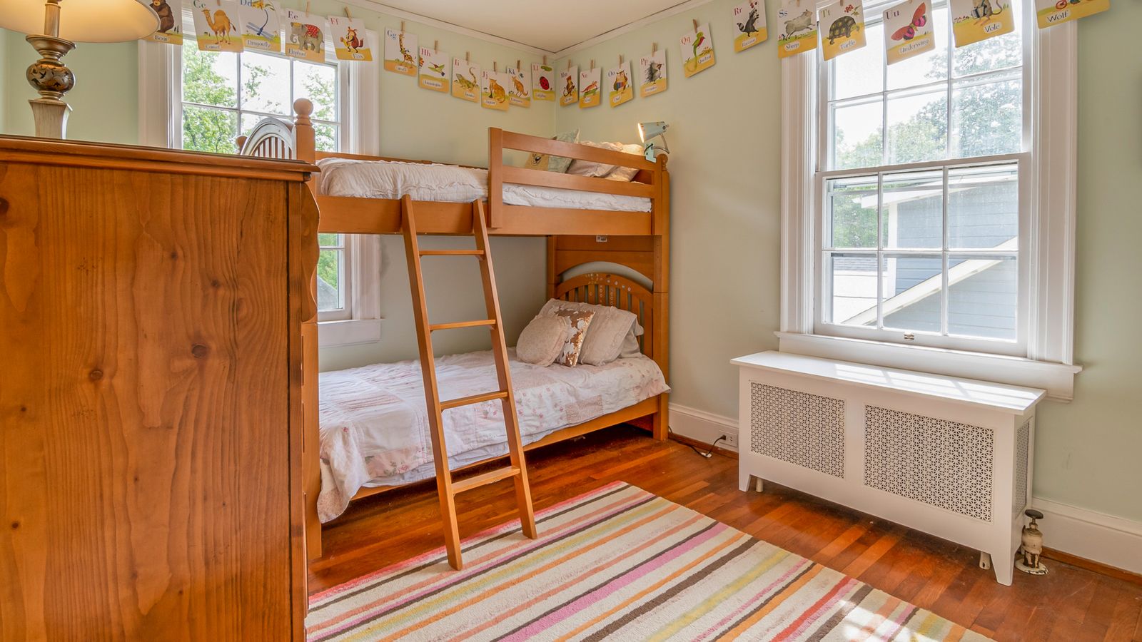 Child climbing a bunk bed ladder in a compact bedroom setting