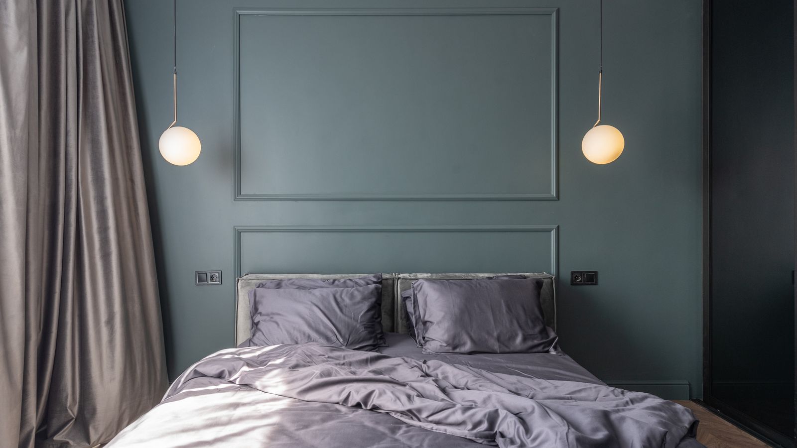 Under-bed storage bins tucked beneath a bed with a bed skirt in a compact room