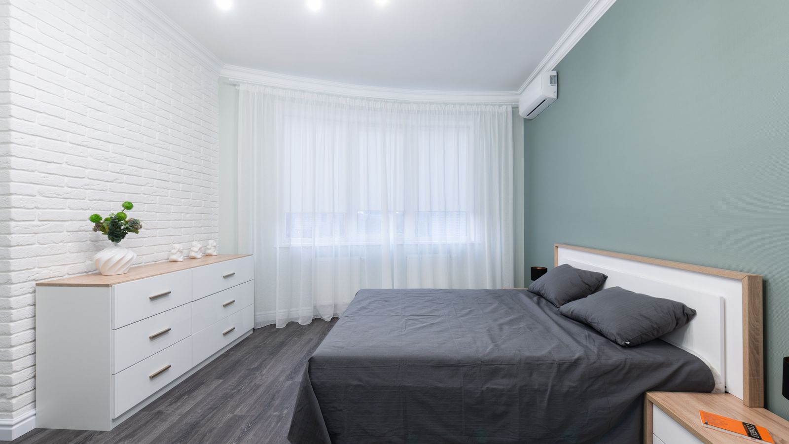 Tall narrow lingerie chest with multiple drawers in a small bedroom corner