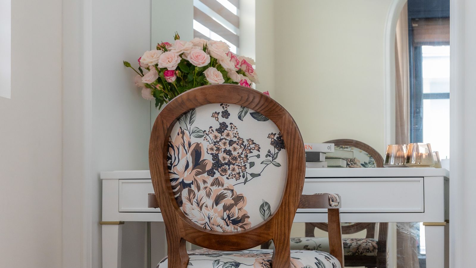 Small floral-accented vanity corner with a compact makeup chair in a modern bedroom