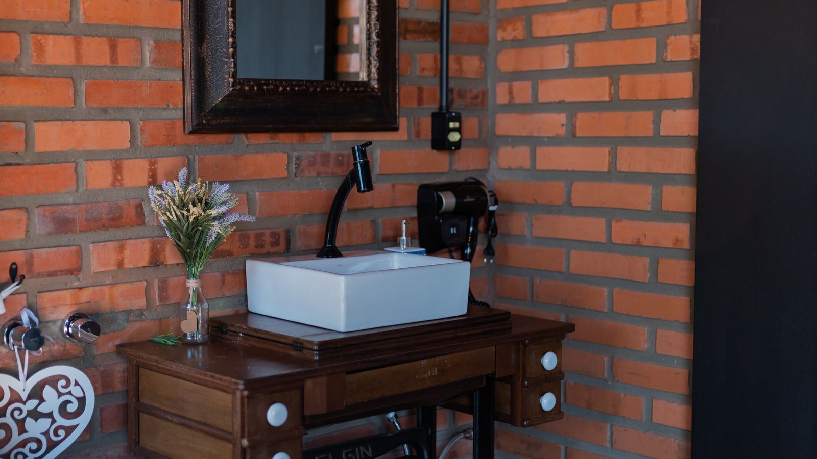 Freestanding bathtub in a rustic bathroom with exposed brick wall