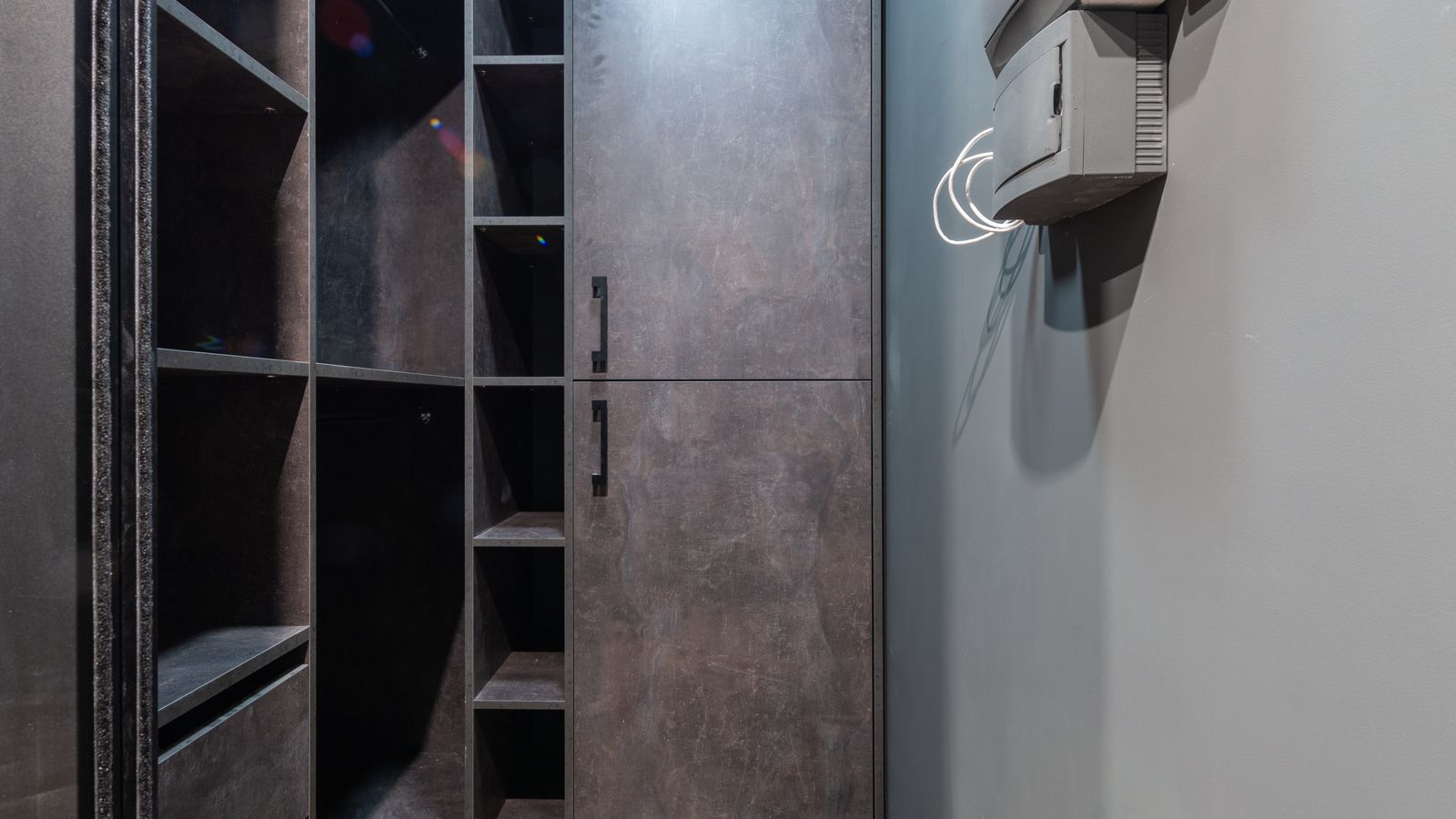 Organized bedroom closet corner with folded clothing storage and mirror