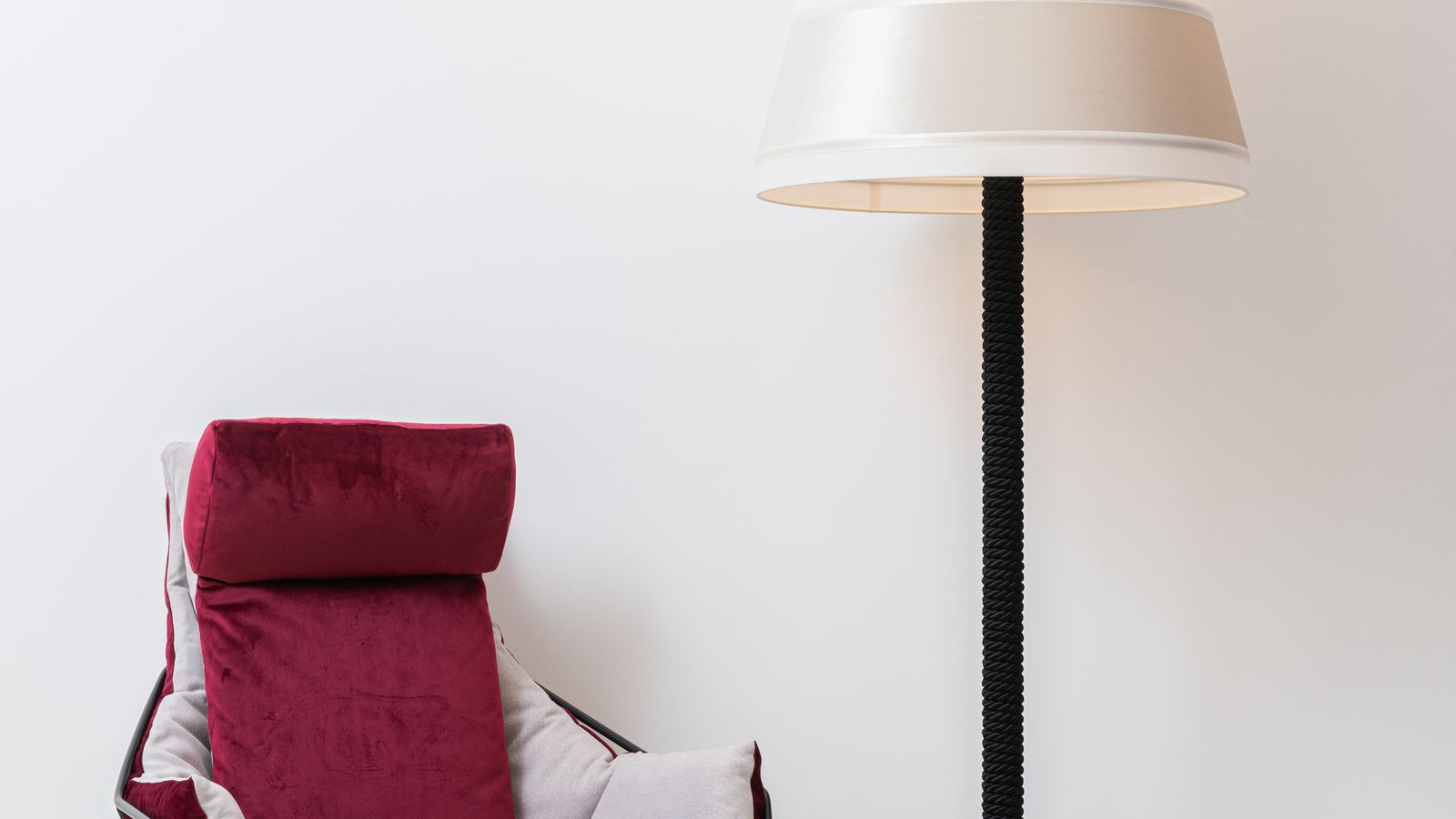 Modern floor lamp casting warm light in the corner of a cozy living room