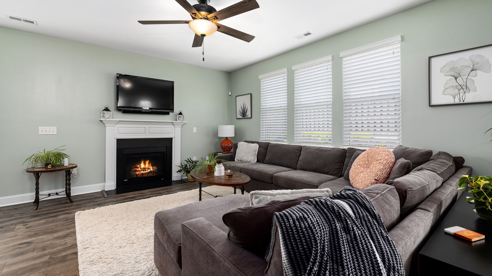 Modern living room with a sectional sofa, TV stand, and fireplace