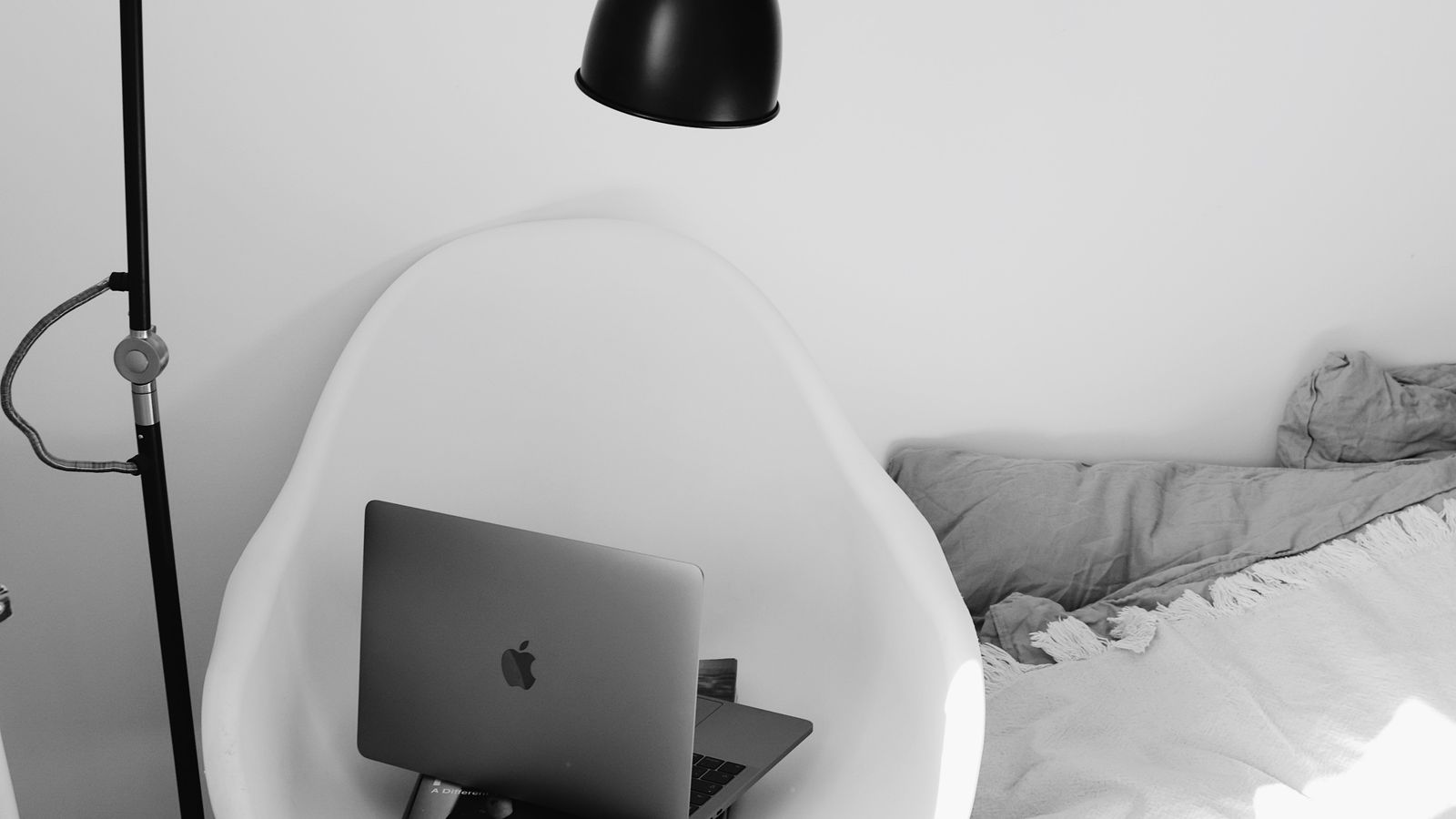 Foldable wooden bed tray set up beside a reading chair