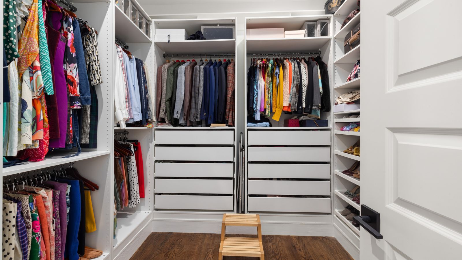 Stacked storage bins and baskets organized inside a walk-in closet