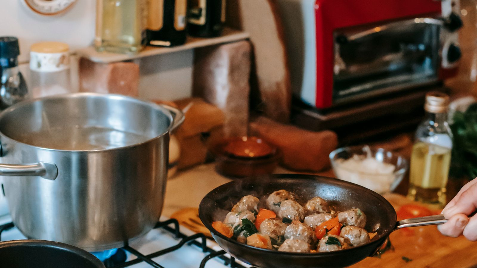 Pot of water simmering on a gas stove burner in a home kitchen