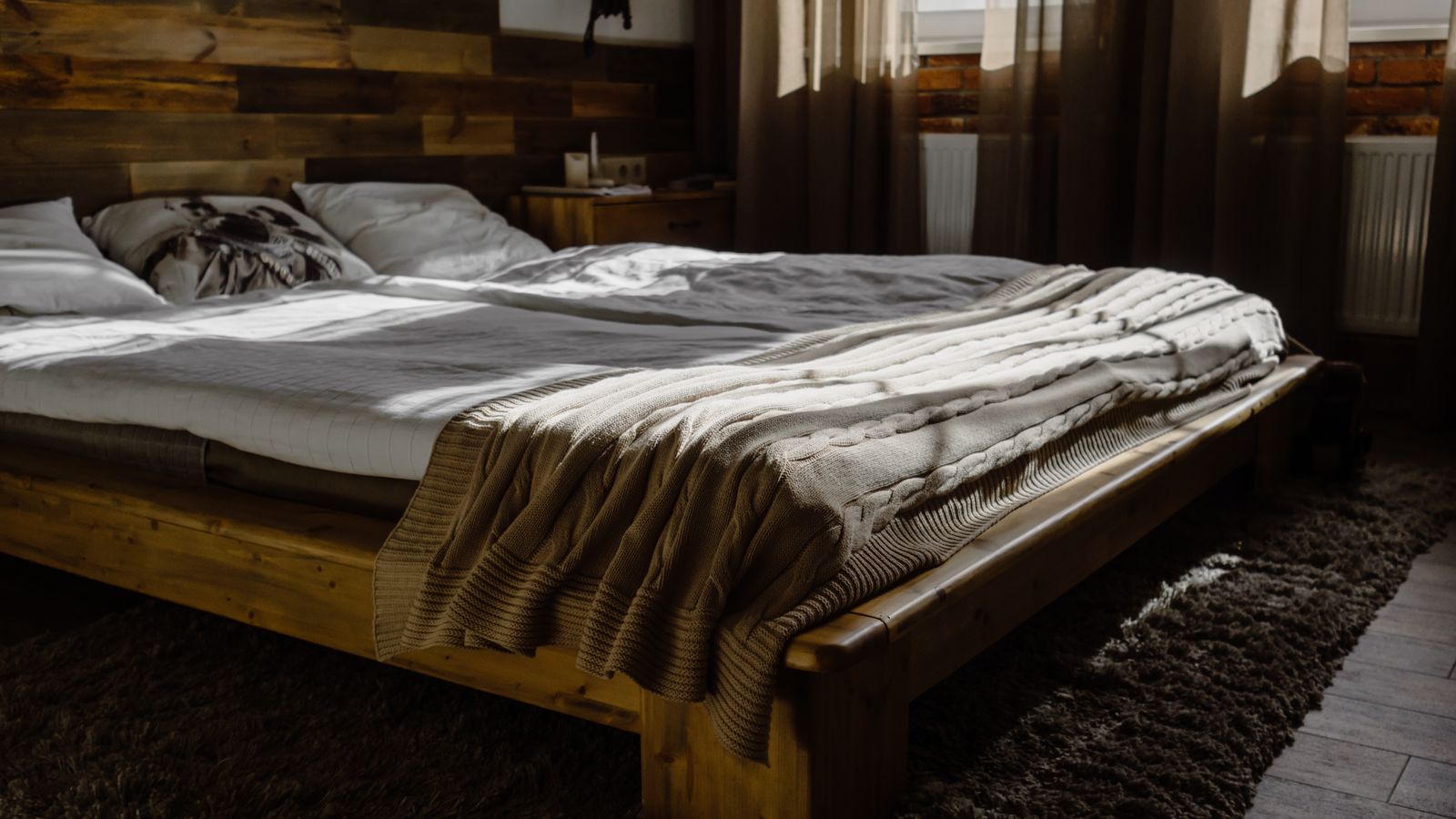 Simplified bedroom setup with a low platform bed frame and neutral bedding