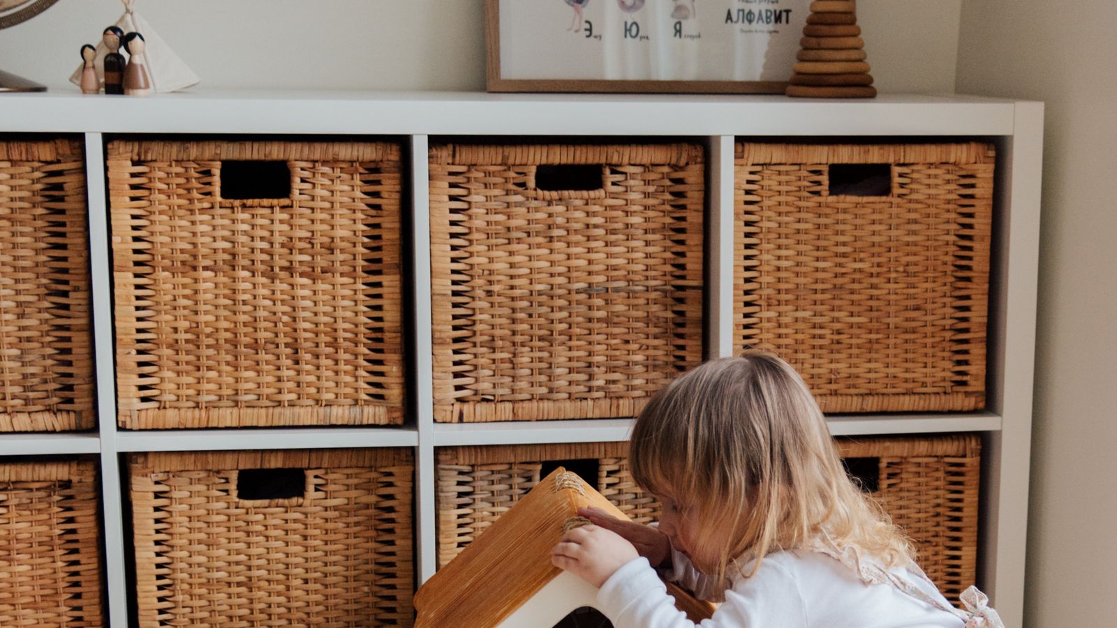 Wooden nursery dresser with folded baby clothes in open drawers