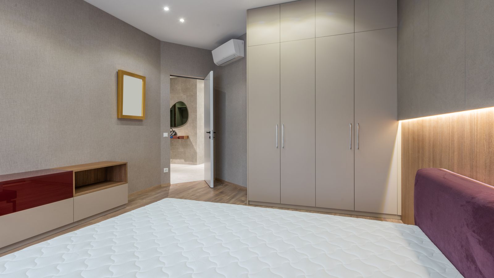 Rolled and wrapped mattress ready for clean storage in a bedroom