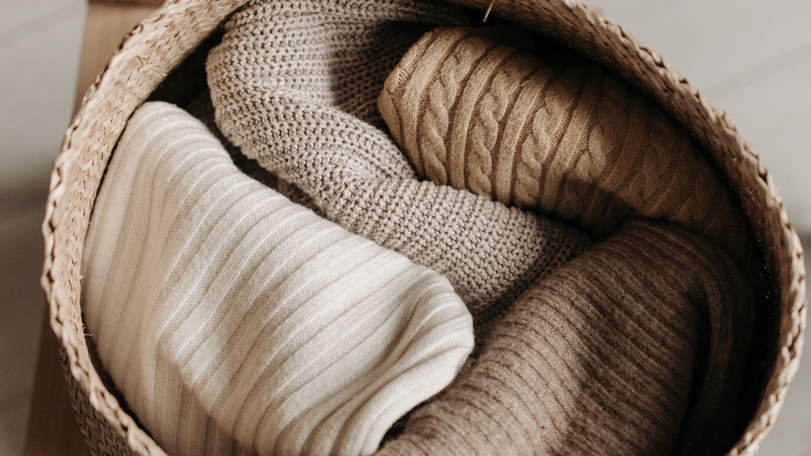 Folded sweaters stacked neatly inside a fabric closet organizer