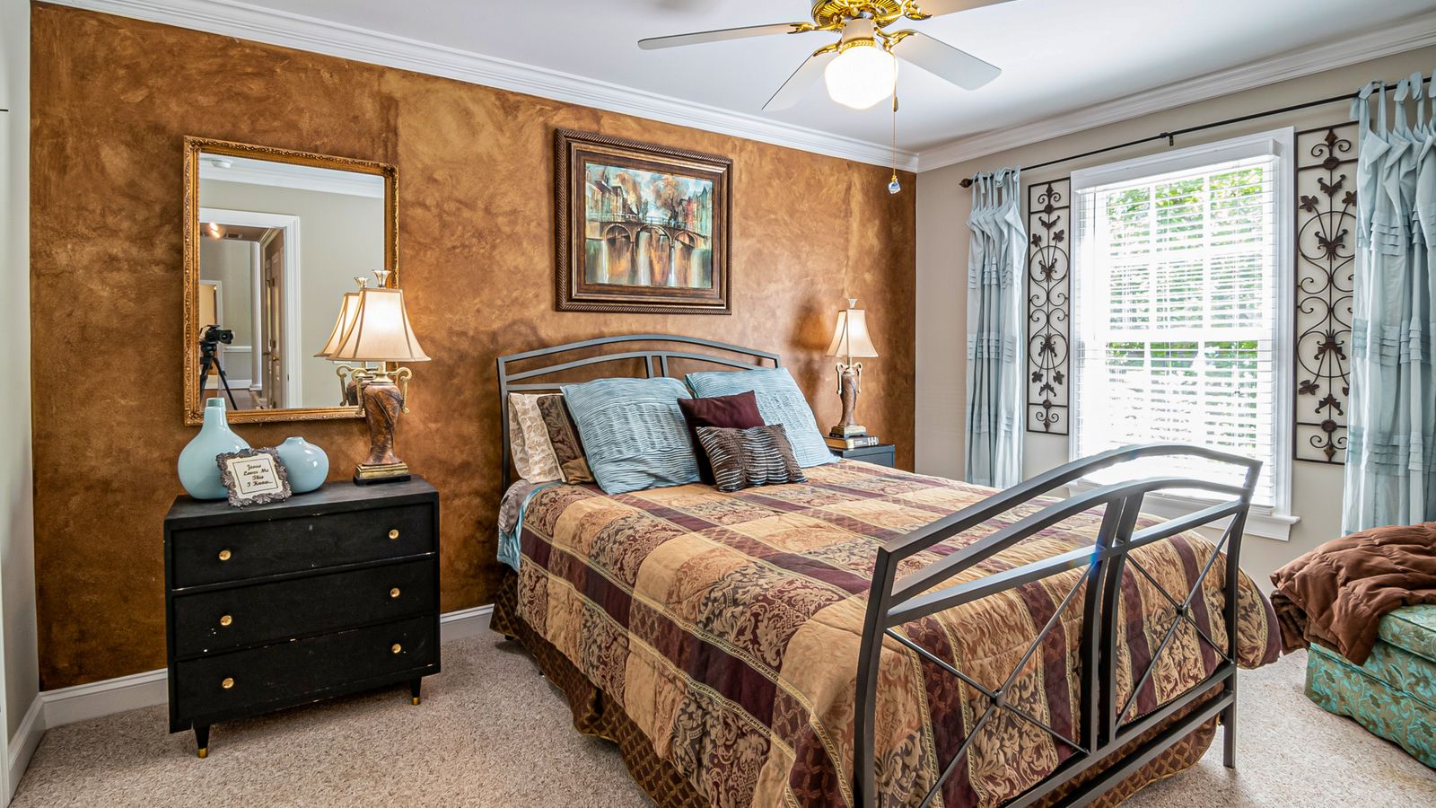 Modern bedroom with a metal bed frame and headboard against a neutral wall