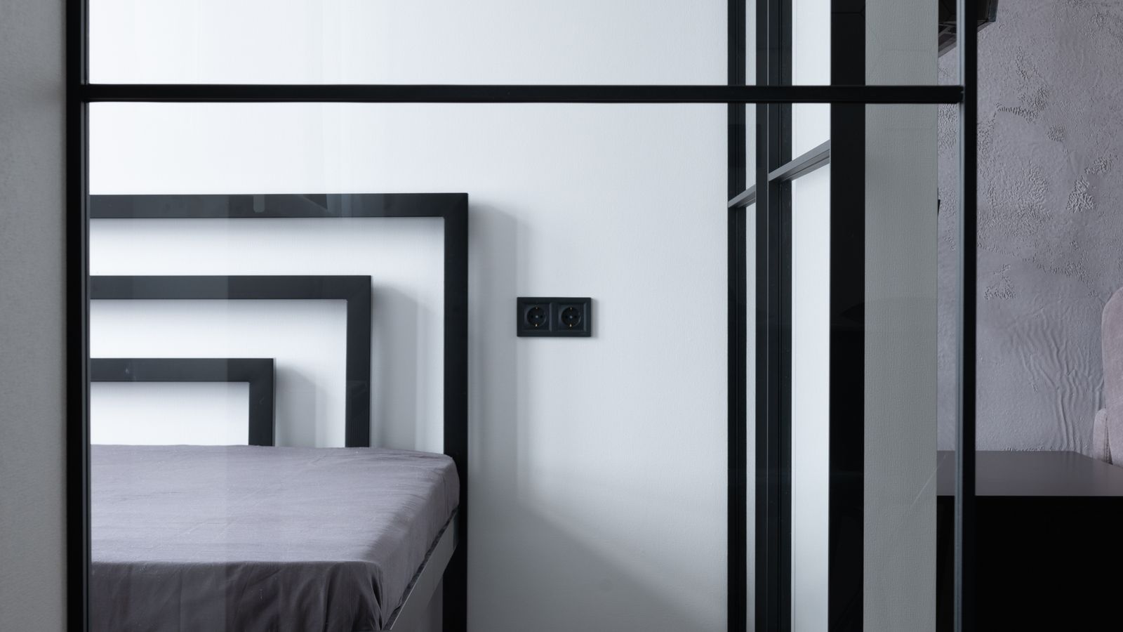 Close-up of a metal headboard frame with decorative bars in a bedroom