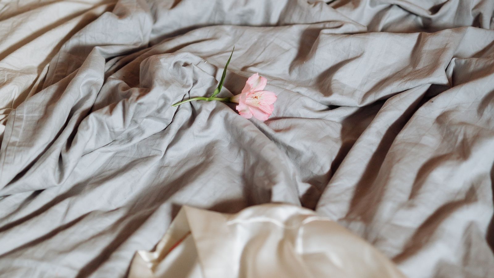 Fitted sheet being tucked around the corner of a compact RV mattress