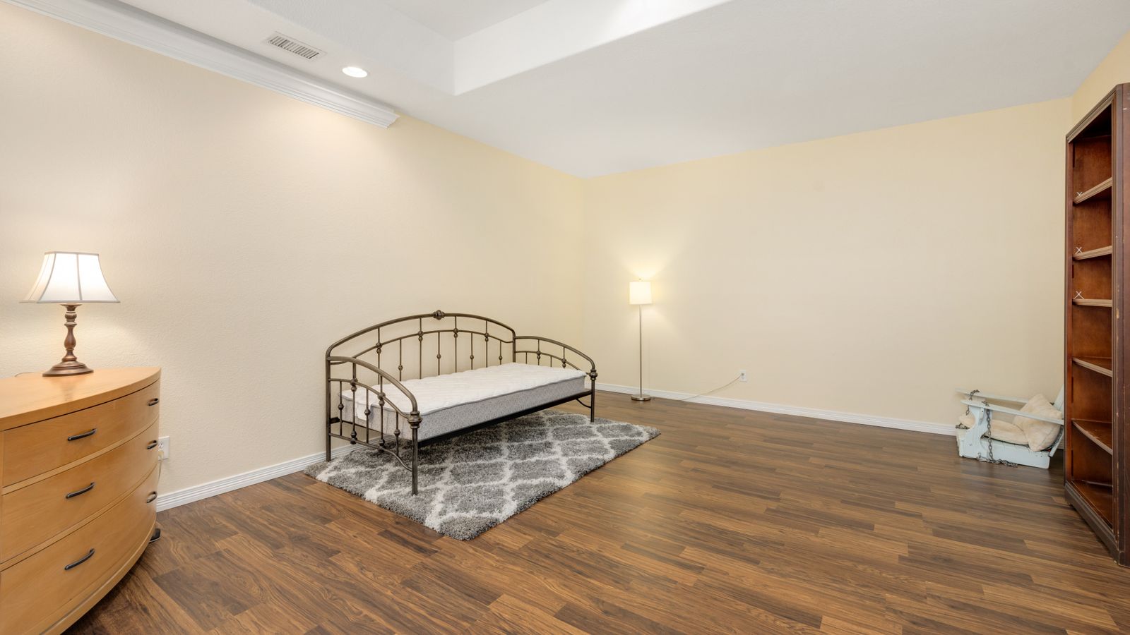 Daybed with a fitted cover and layered throw pillows in a bedroom corner