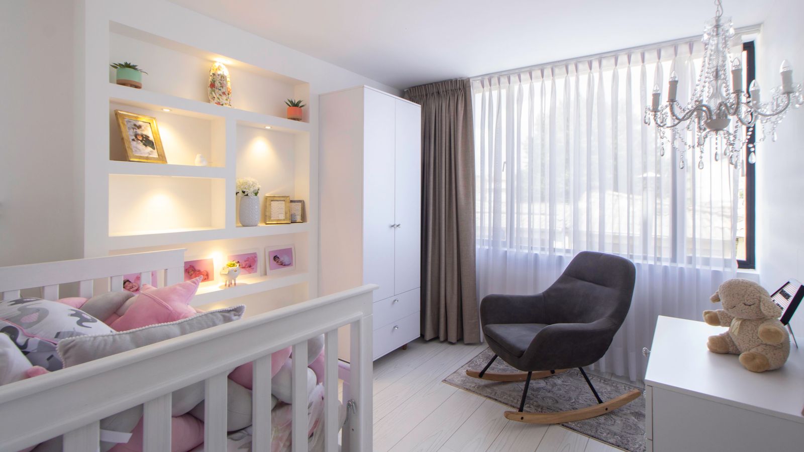 Upholstered nursery glider chair positioned in a soft-lit nursery corner near a crib