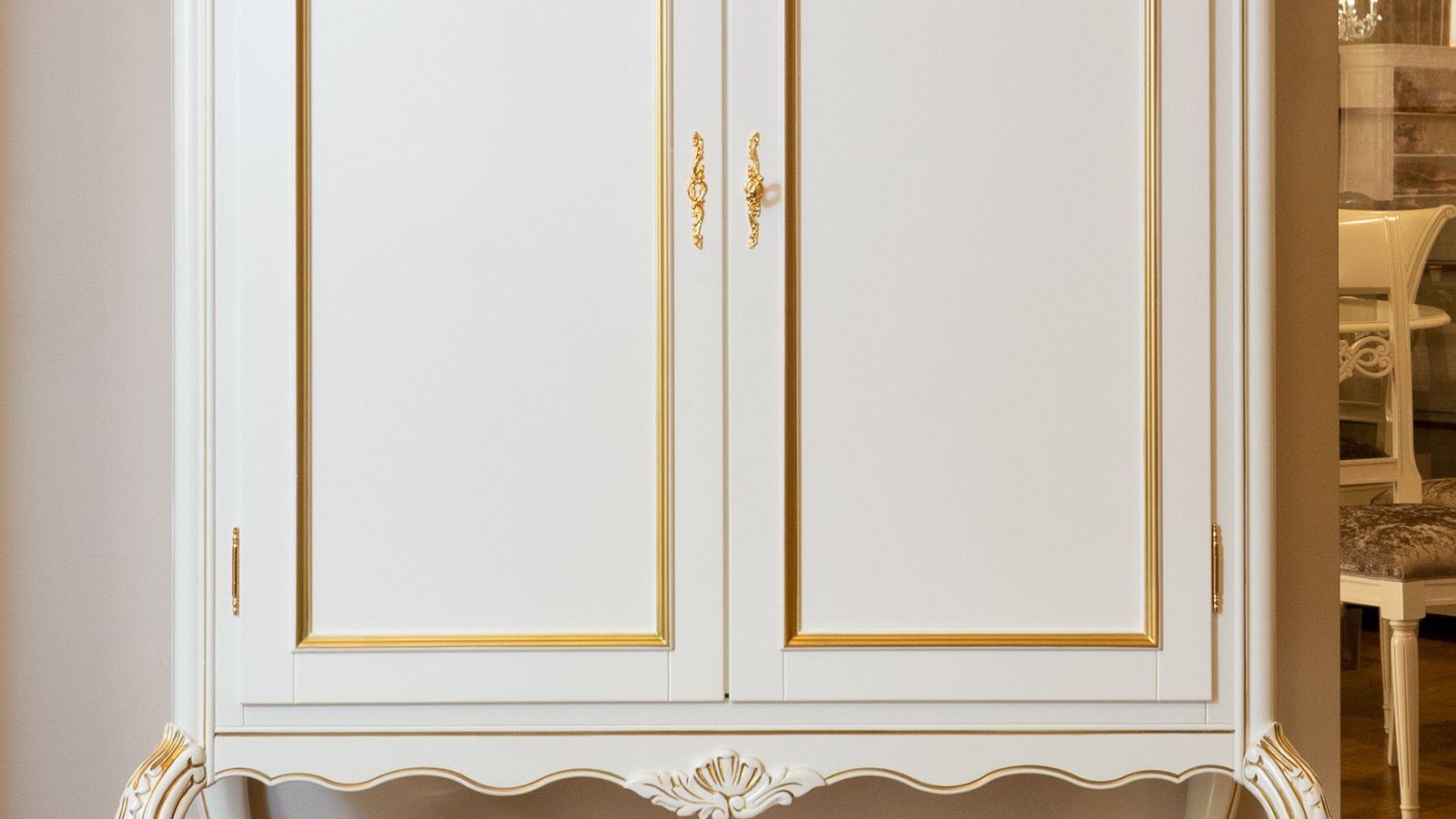 Freestanding wooden armoire wardrobe used for clothing and accessory storage in a bedroom