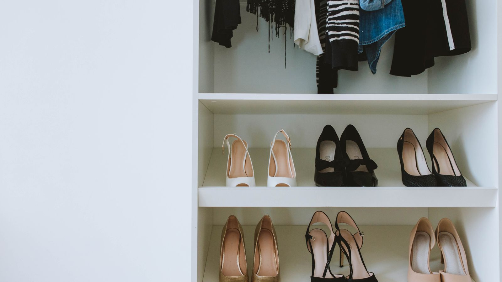 Stacked clear plastic storage bins organized on shelving in a closet
