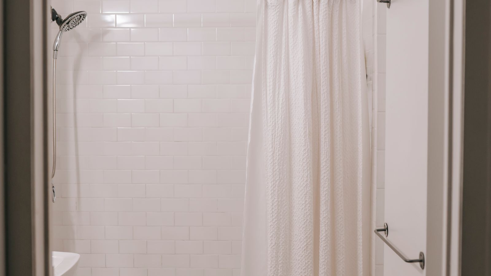 Neutral shower liner hanging in a compact tub and shower combo
