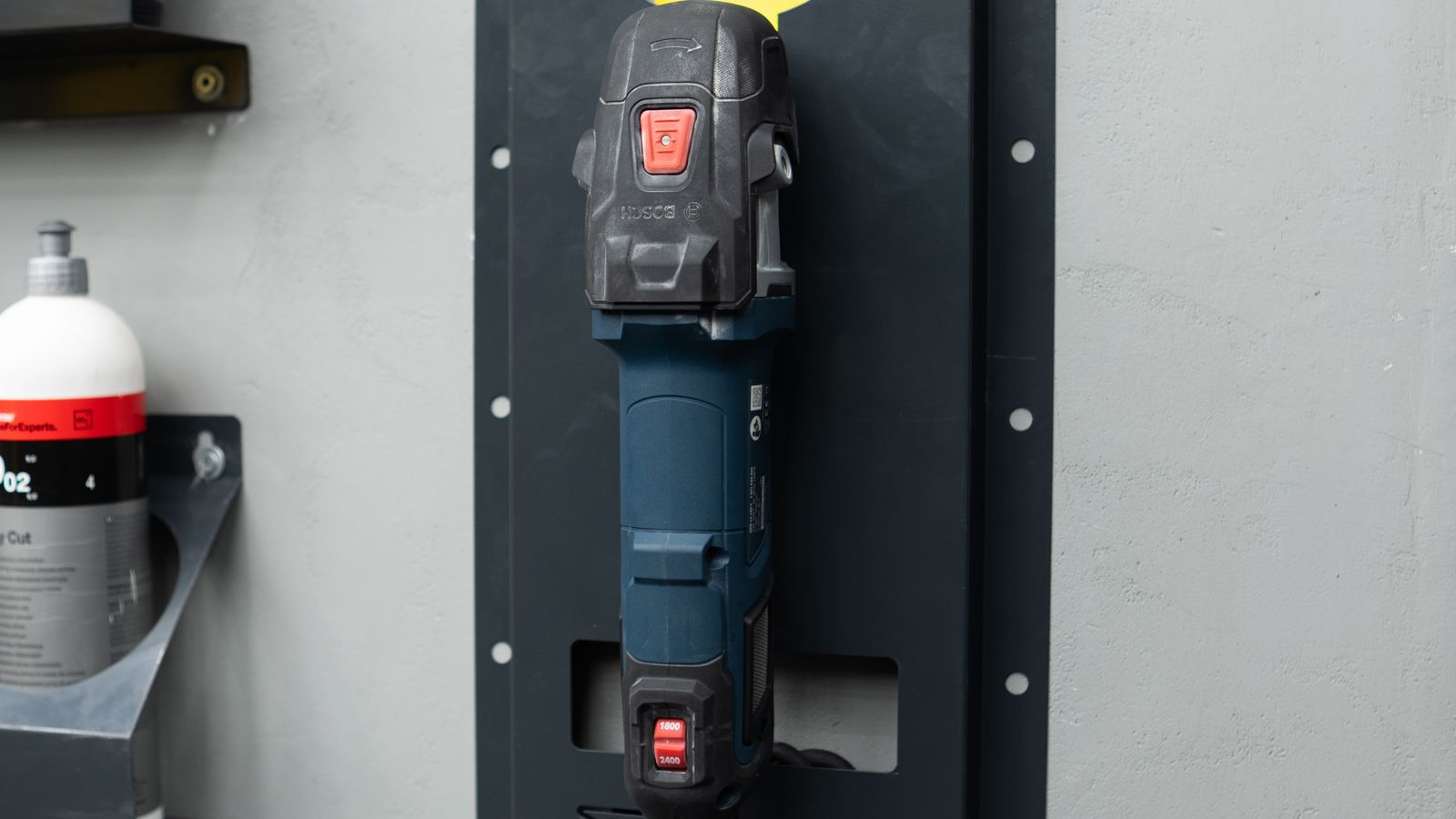 Wall-mounted storage brackets securing tools and shelving to a workshop wall